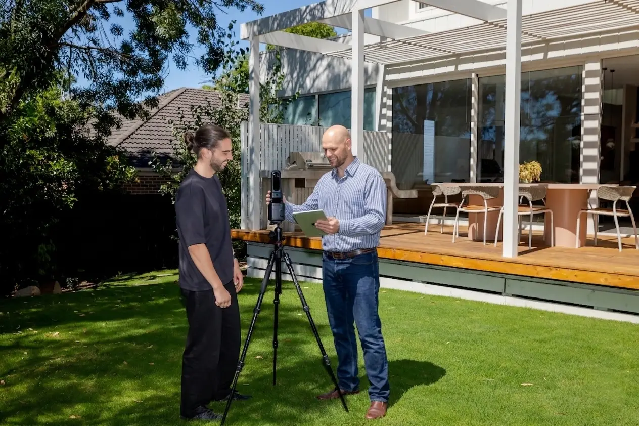 Real estate photographer explaining how to use and operate an iGUIDE scanning device