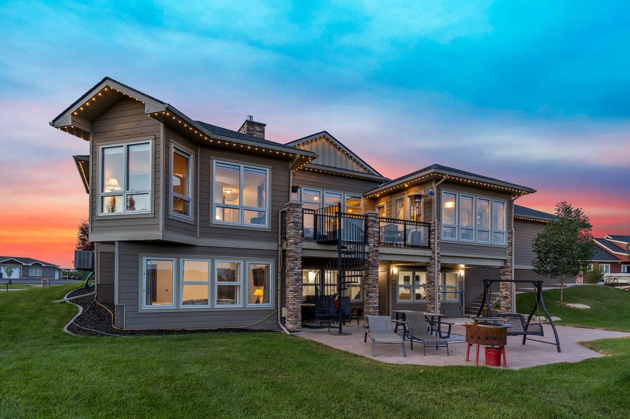 Twilight photo of a house in Okotoks with illuminated windows