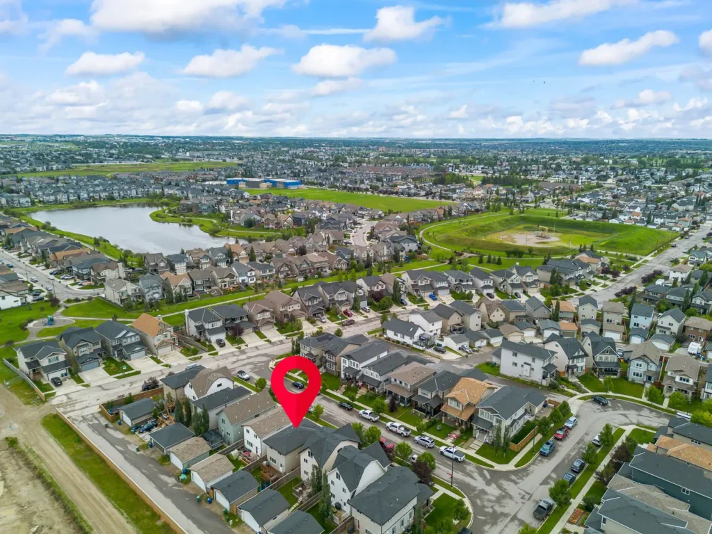 Drone shot of a house in Airdrie with a lake nearbuy