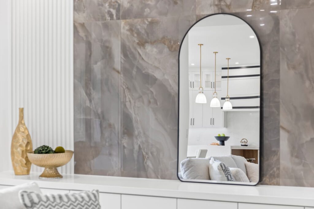 Style Shots. Design photo of a mirror reflecting kitchen fixtures and interior decor.