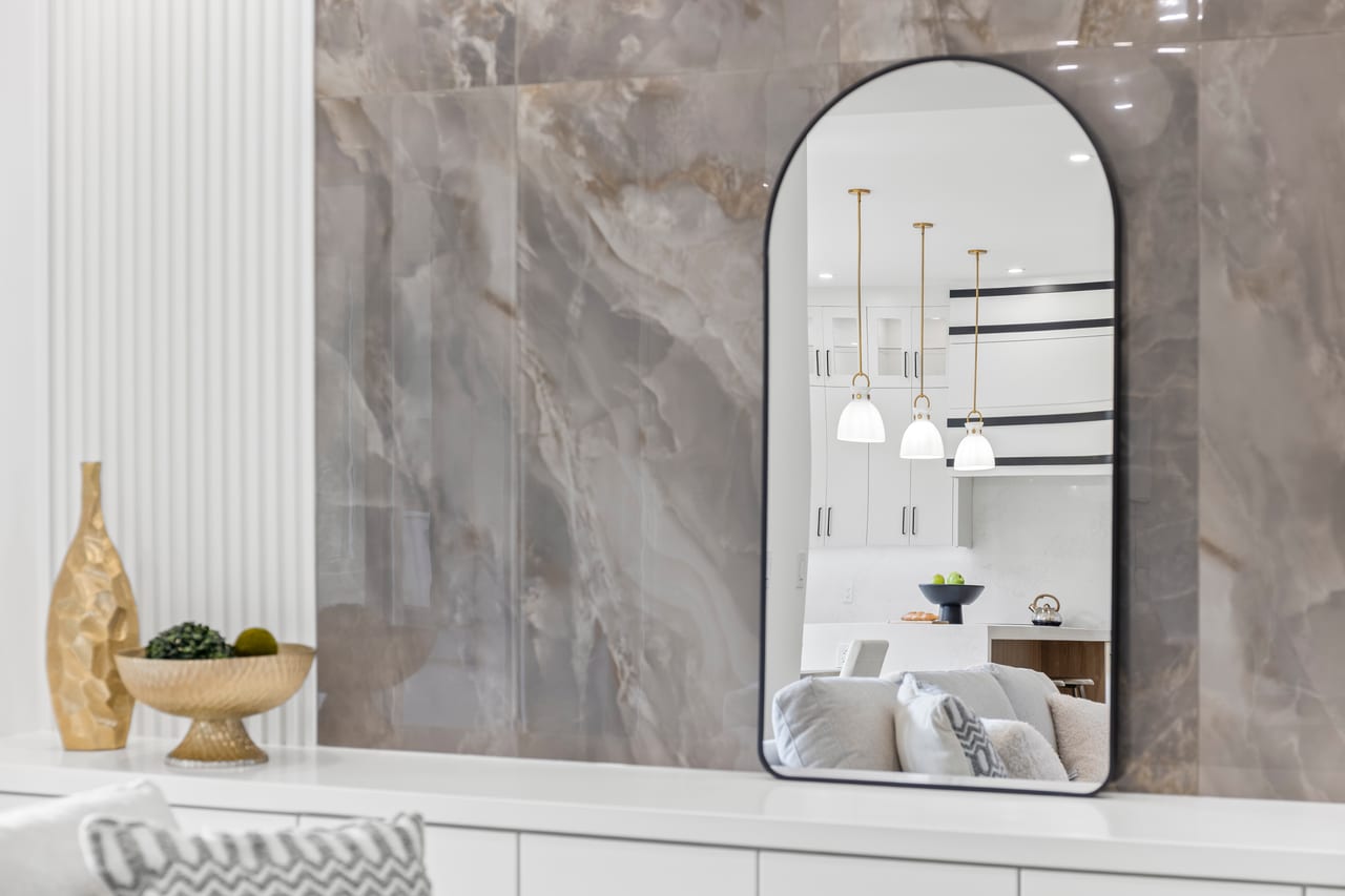 Style Shots. Design photo of a mirror reflecting kitchen fixtures and interior decor.